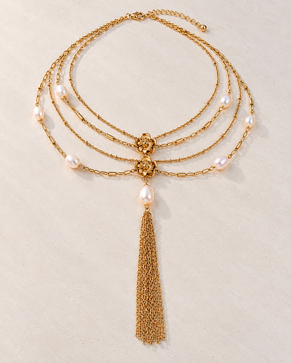 Choker Victoire de cadenas doradas y perlas sobre cemento blanco