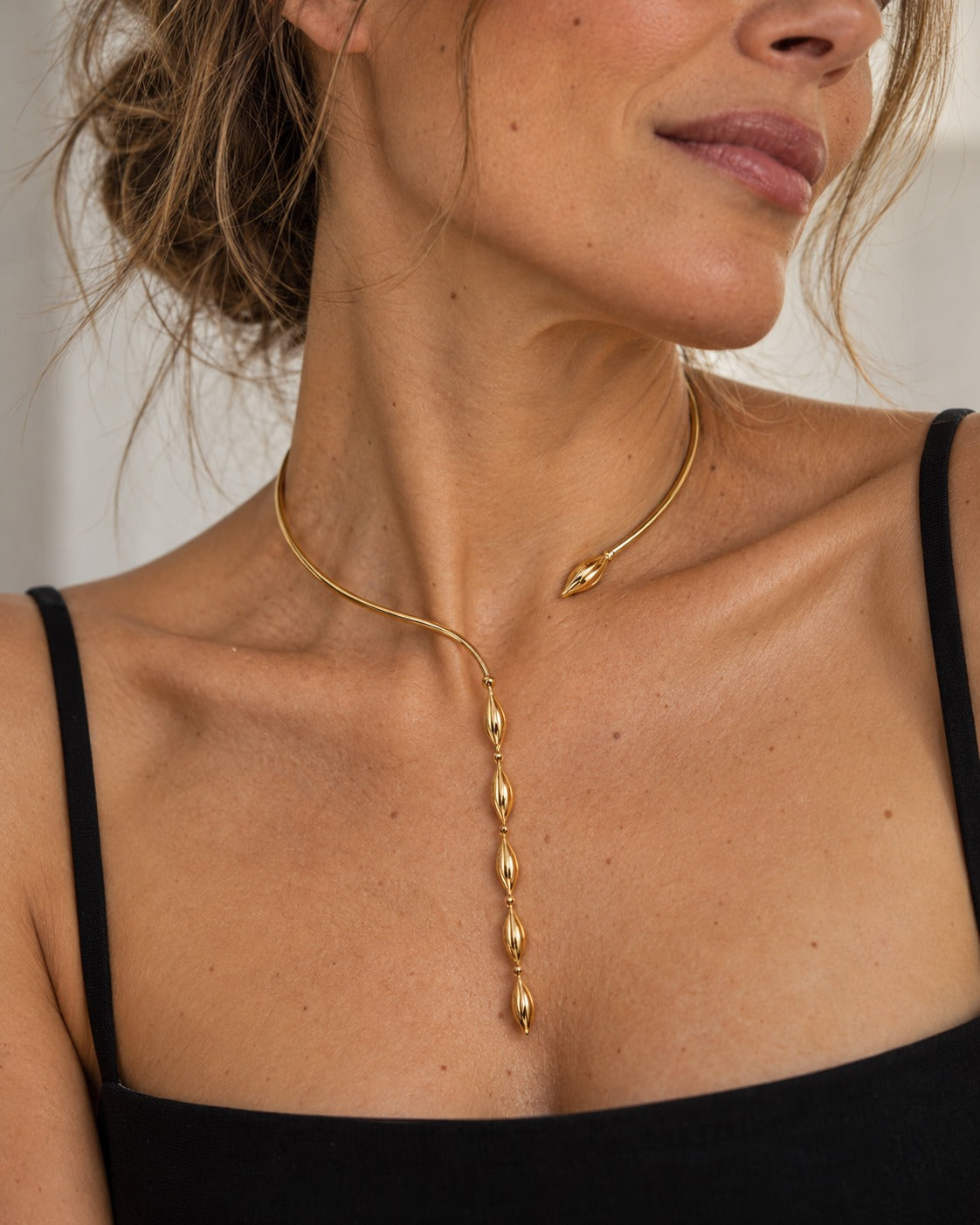 Collar Delphine lariat de gotas doradas puesto en modelo